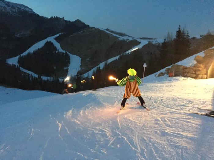 Masked torchlight descent with ski instructors